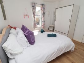 A bedroom with a bed and wardrobe at The Old Bank House in Red Row near Amble