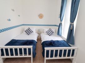 A bedroom with two single beds and decorative wall features at The Old Bank House Red Row near Amble