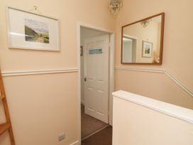 A hallway with a mirror and wall art at The Old Bank House Red Row near Amble