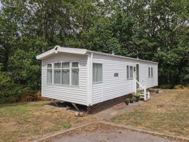 A mobile home with steps and plants at Plot 13A