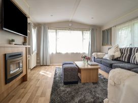 A living room with a television and sofa at Plot 13A