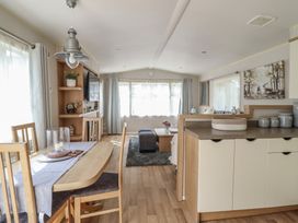 A living room and dining area with a dining table and sofa at Plot 13A