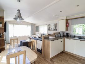 A living room with a dining area and kitchen features at Plot 13A