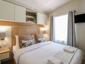 A bedroom with a bed and bedside lamps at Plot 13A 