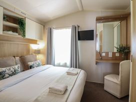 A bedroom with a bed and a mirror at Plot 13A