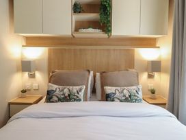 A bedroom with bed and decorative pillows at Plot 13A