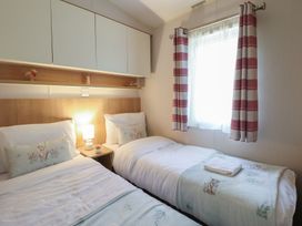 A bedroom with two beds and a window at Plot 13A