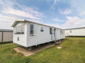 A mobile home with stairs and grass area at 42 Oak Green