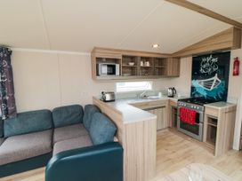 A kitchen with a sofa and appliances at 42 Oak Green
