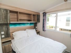 A bedroom with a bed and shelves at 42 Oak Green