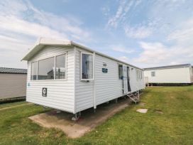 A mobile home with grass and steps at 42 Oak Green