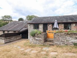 An outdoor view of a building with a stone wall and steps at Iris at Stancombe Manor Sherford near Chillington