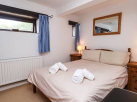 A bedroom with a bed and nightstand at Iris at Stancombe Manor Sherford near Chillington