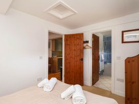 A bedroom with a bed and towels visible at Iris at Stancombe Manor Sherford near Chillington