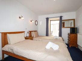 A bedroom with two beds and a television at Iris at Stancombe Manor Sherford near Chillington