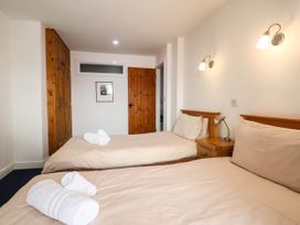 A bedroom with two single beds and wooden furniture at Iris at Stancombe Manor Sherford near Chillington