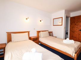 A bedroom with two beds and a mirror at Iris at Stancombe Manor Sherford near Chillington