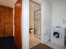 A bathroom with a shower and washing machine at Iris at Stancombe Manor Sherford near Chillington