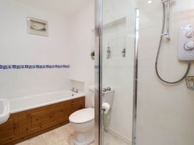 A bathroom with a bathtub, shower, toilet, and sink at Iris at Stancombe Manor Sherford near Chillington
