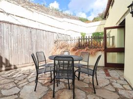 An outdoor seating area with a table and chairs at Iris at Stancombe Manor in Sherford near Chillington