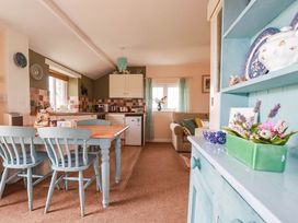 A kitchen with table and chairs and cabinets at The Granary in 