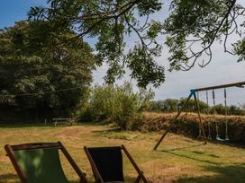 An outdoor area with a swing and deck chairs at The Granary in 