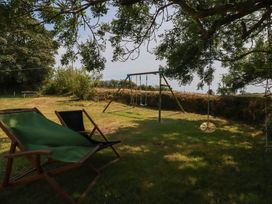 A garden with a swing set and deck chair at The Granary 