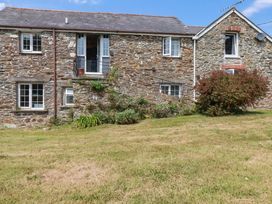 An outdoor view of a stone house with grass and shrubs at The Granary in 