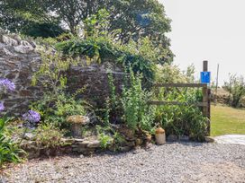 An outdoor area with a stone wall and plants at The Granary in 