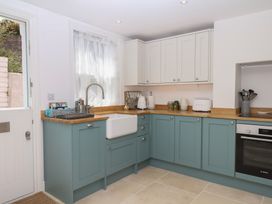 A kitchen with cabinets, sink, and appliances at Tower View Cottage in Lympstone