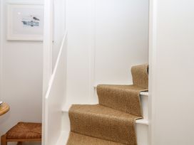 A staircase leading up with carpet and a picture frame at Tower View Cottage Lympstone