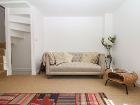 A snug with a sofa and a staircase at Tower View Cottage in Lympstone