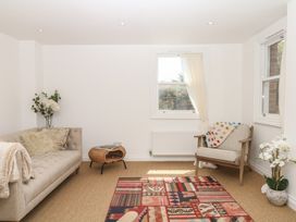 A living room with a sofa, chair, and rug at Tower View Cottage in Lympstone
