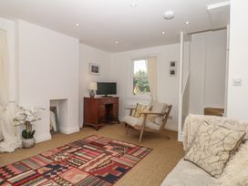 A living room with a desk and television at Tower View Cottage in Lympstone