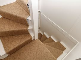 A staircase with carpeted steps and a handrail at Tower View Cottage in Lympstone