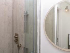 A shower with controls and a mirror at Tower View Cottage in Lympstone