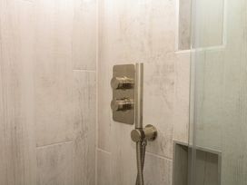 A shower with controls and a handheld showerhead at Tower View Cottage in Lympstone