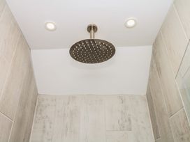 A shower with a large shower head at Tower View Cottage in Lympstone