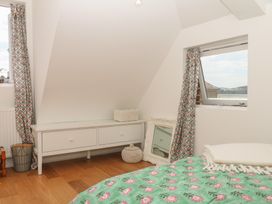 A bedroom with a bed, drawer unit, and window at Tower View Cottage in Lympstone