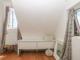 An attic room with a window and storage unit at Tower View Cottage in Lympstone
