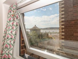 A view through a window with a curtain at Tower View Cottage in Lympstone