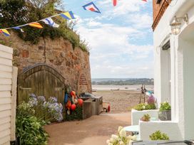 An outdoor area with a stone wall and fishing gear at Tower View Cottage in Lympstone