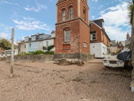 An outdoor area with a brick building and a boat at Tower View Cottage in Lympstone