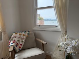 A living room with a chair by the window at Tower View Cottage in Lympstone