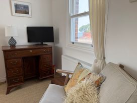 A living room with a television, lamp and dresser at Tower View Cottage in Lympstone