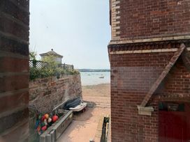 A view of the sea with boats and a pebbled beach at Tower View Cottage in Lympstone
