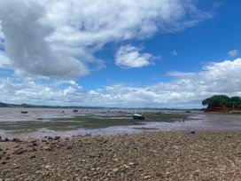 A view of boats on water with rocks and clouds at Tower View Cottage in Lympstone