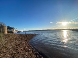 A shoreline with water and boats at Tower View Cottage in Lympstone