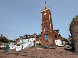 A tower and buildings with laundry on a clothesline at Tower View Cottage in Lympstone