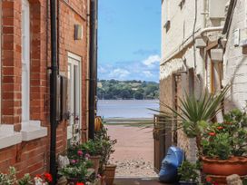 A view between buildings towards the beach at Tower View Cottage in Lympstone